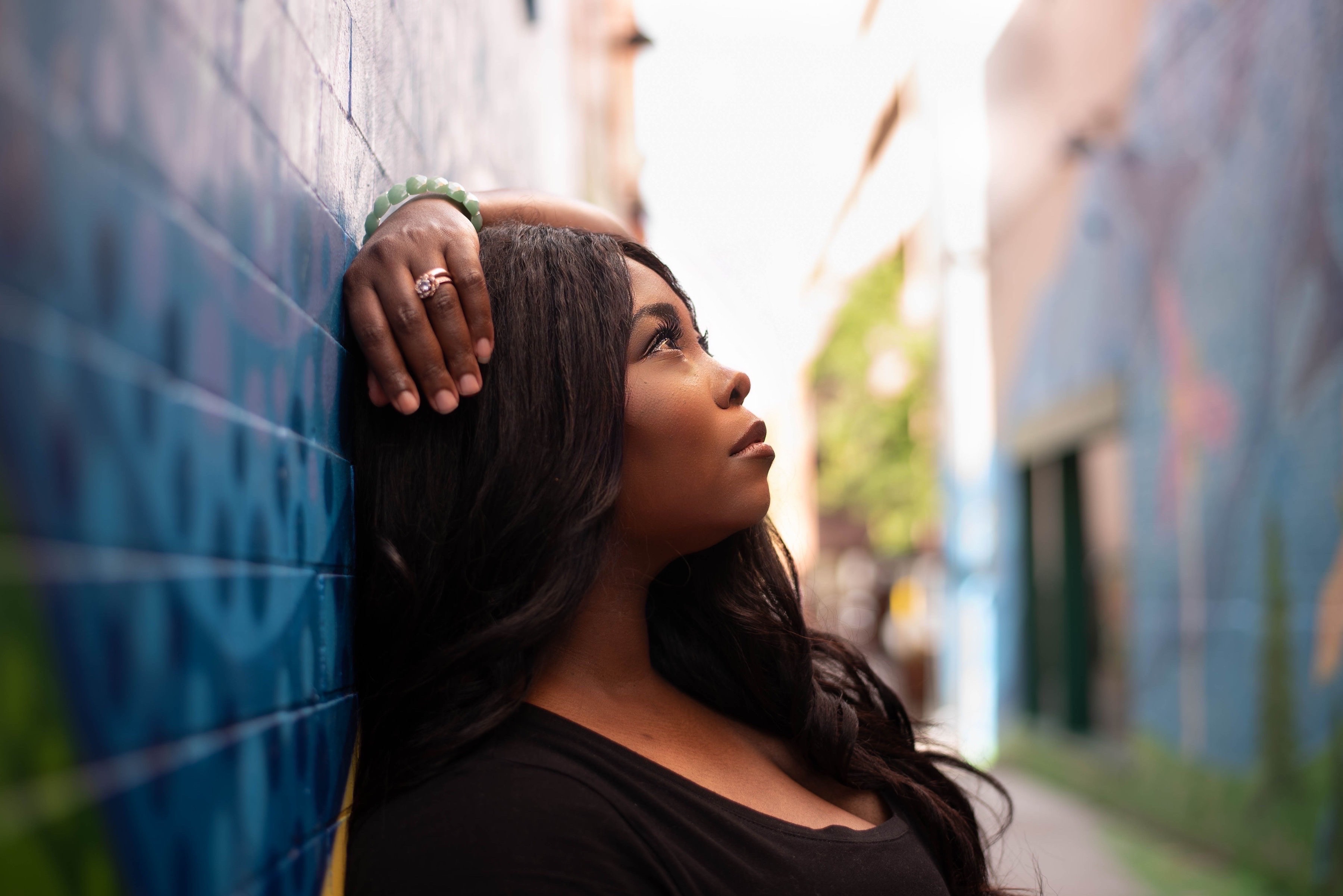 Shayla Micole beside a blue brick wall